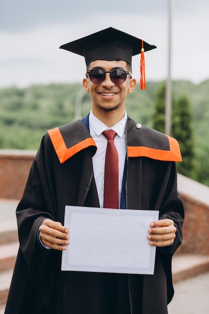 Young smiling arabian male on his graduation day in university Education qualification and gown concept