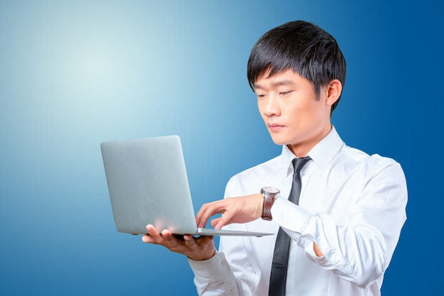 Young smiling asian business man holding laptop