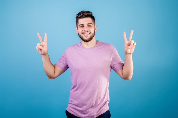 Young smiling bearded man showing peace gesture with fingers