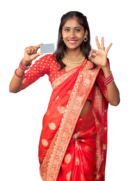 Young smiling beautiful girl posing with a credit or debit card on a white background