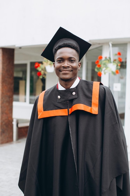 Young smiling black male on his graduation day in university Education qualification and gown concept