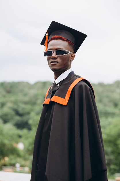 Young smiling black male on his graduation day in university Education qualification and gown concept