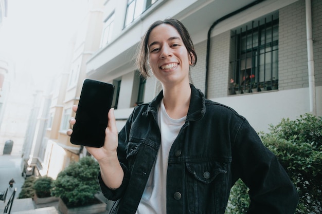 Young smiling broadly woman on sunny day using smartphoneGood vibesModern technology copy space