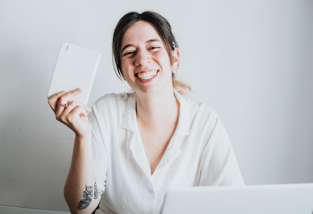 Young and smiling business woman working with laptop while taking notes portrait image copy space