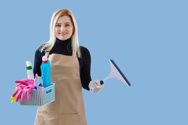 Young smiling cleaner woman. Isolated over blue background.