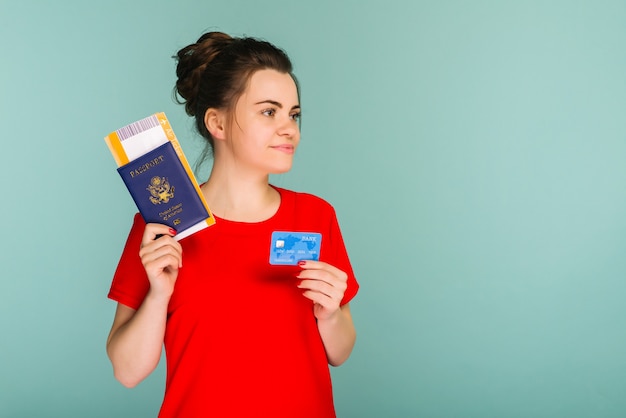 Young smiling excited woman student holding passport boarding pass ticket