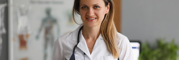 Young smiling female doctor holding clipboard closeup