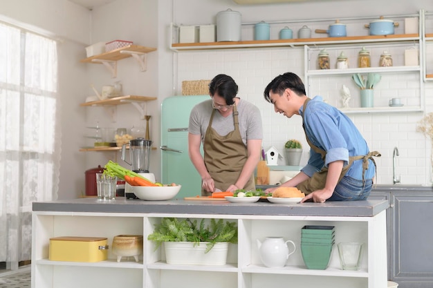 Young smiling gay couple cooking together in the kitchen at home LGBTQ and diversity concept