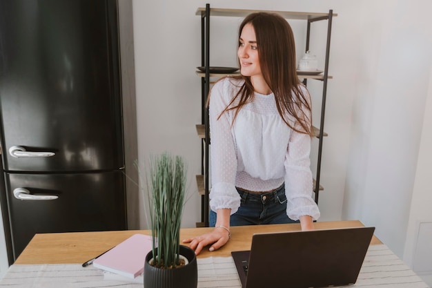 a young smiling girl stands near the office desk freelance and business