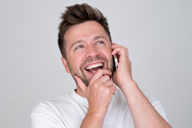 Young smiling happy caucasian man talking speaking by mobile cell phone