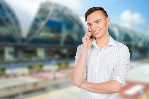 Young smiling man talking on the mobile phone