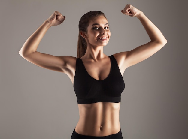 Young smiling model doing strength training in studio