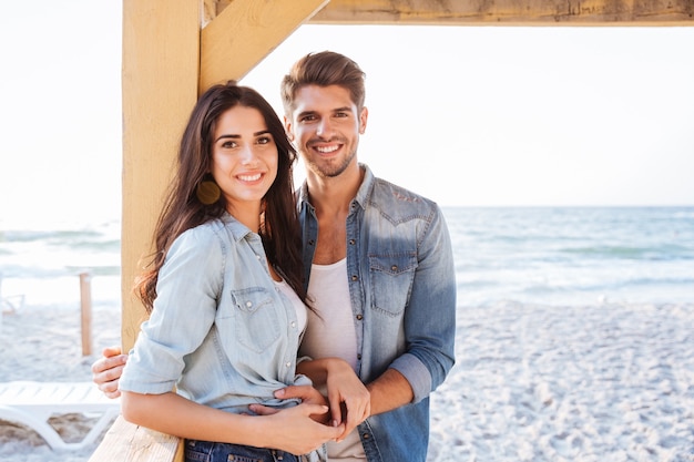 Young smiling romantic couple in love standing together at the beach