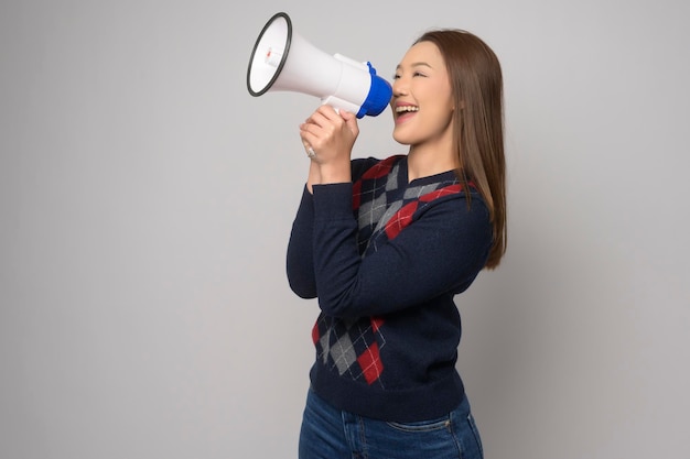 Young smiling woman holding megaphone over white background studiox9