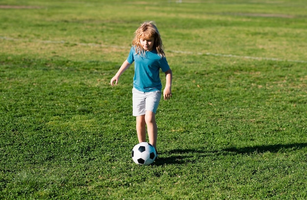 Young soccer player young boy kicks the soccer ball football player in motion boy in movement cute