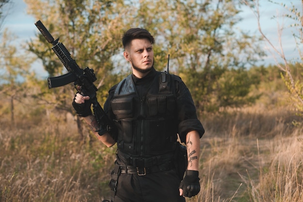 Young soldier in black uniform with an assault rifle