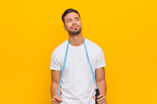 Young south-asian man holding a jump rope.