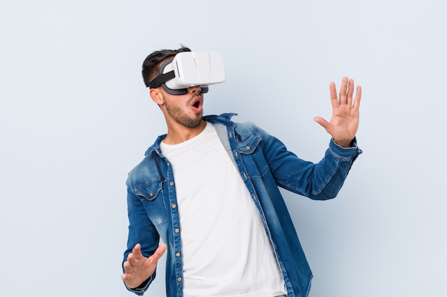 Young south-asian man playing with virtual reality glasses