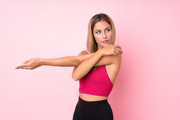 Young sport blonde woman background stretching arm