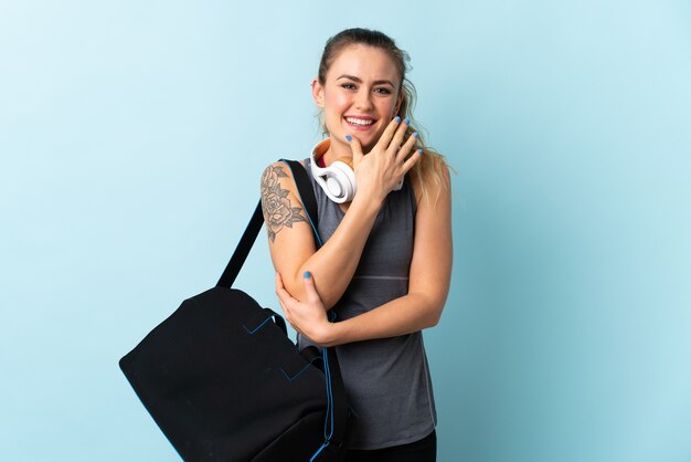 Young sport Brazilian woman with sport bag isolated  happy and smiling