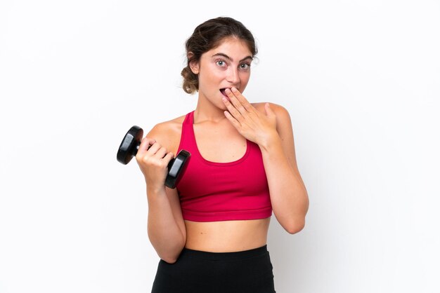 Young sport caucasian woman making weightlifting isolated on white background happy and smiling covering mouth with hand