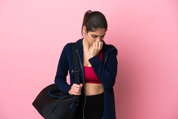 Young sport caucasian woman with sport bag isolated on pink background having doubts