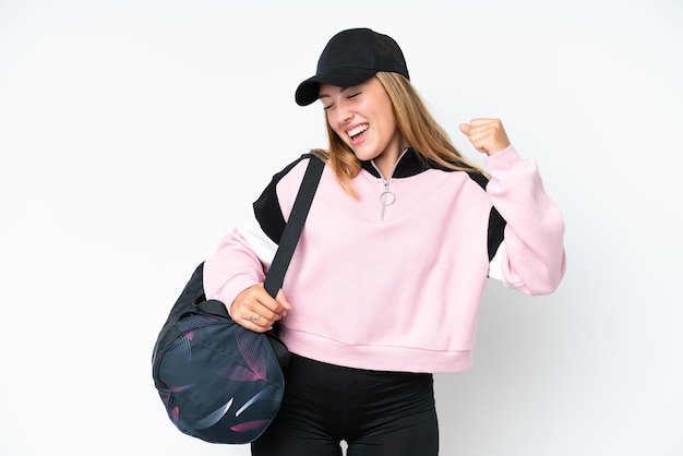 Young sport caucasian woman with sport bag isolated on white background celebrating a victory