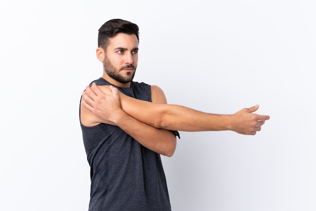 Young sport handsome man with beard over white stretching arm