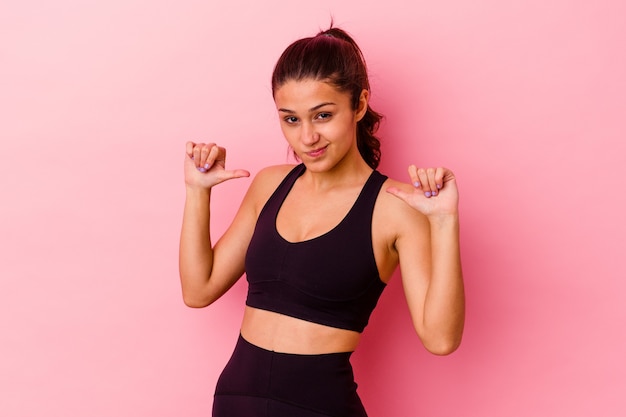 Young sport Indian woman isolated on pink feels proud and self confident, example to follow.