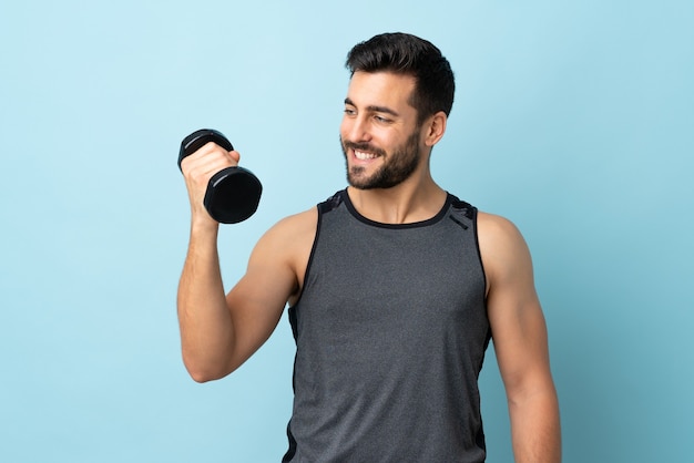 Young sport man with beard making weightlifting with happy expression