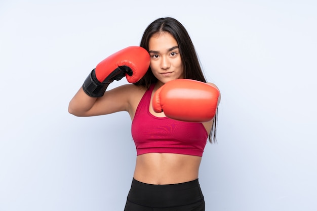 Young sport woman on blue with boxing gloves