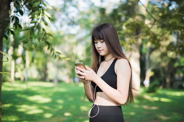 Young sport woman using mobile in the park