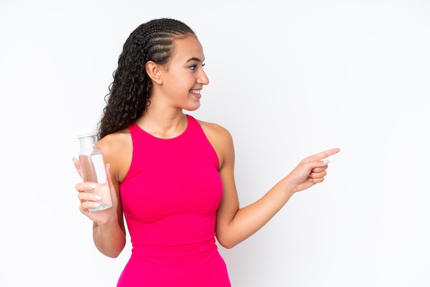 Young sport woman with a bottle of water isolated on white pointing to the side to present a product