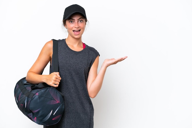 Young sport woman with sport bag isolated on white background presenting an idea while looking smiling towards