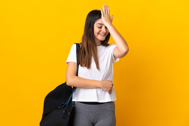 Young sport woman with sport bag isolated on yellow wall has realized something and intending the solution