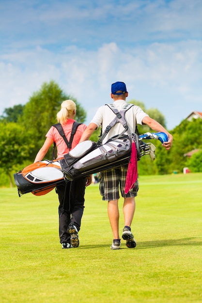 Young sportive couple playing golf on a course