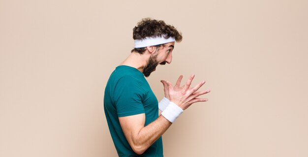 Photo young sports man expressing a concept against flat wall