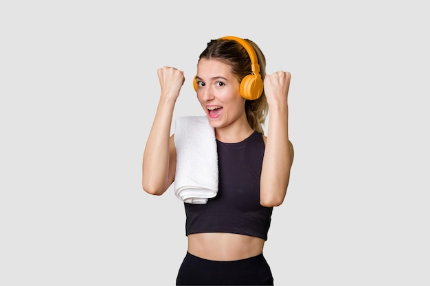 A young sportswoman enjoying music on her mobile phone fueled with motivation