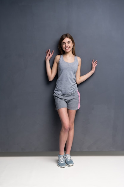 Photo young sporty female model isolated on gray in full body.