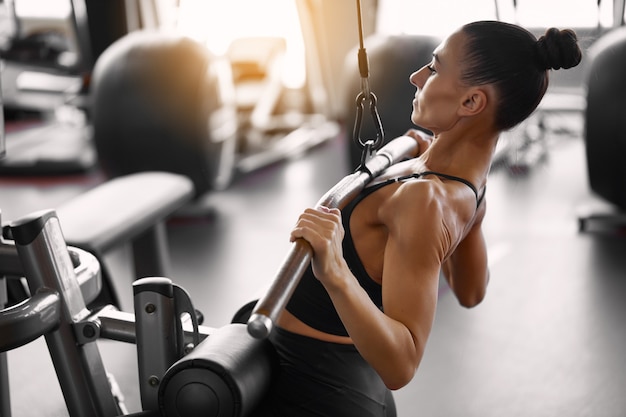 Young sporty woman doing workout in the gym