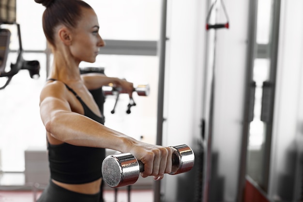 Young sporty woman doing workout in the gym