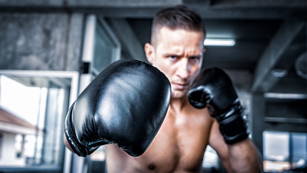 young strong sports man boxer make exercises in gym