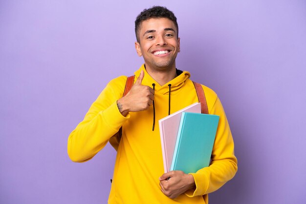 Young student Brazilian man isolated on purple background giving a thumbs up gesture