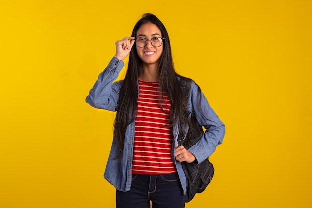 Young student holding backpack and books in studio photo