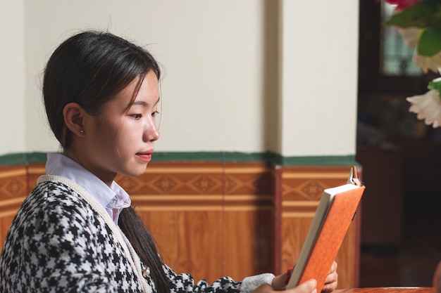 A young student is reading a school book for learning and prepare for exam and homework on the table education and study concept backside shot copy space for individual text