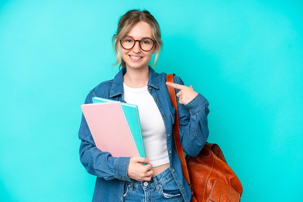 Young student woman isolated on blue background giving a thumbs up gesture