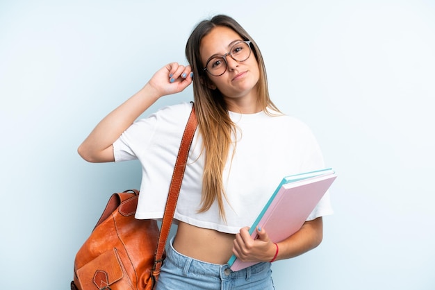 Young student woman isolated on blue background having doubts