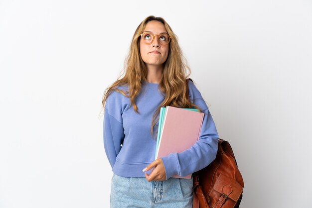 Young student woman isolated and looking up