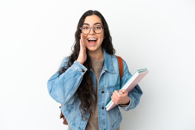 Young student woman isolated on white background with surprise and shocked facial expression