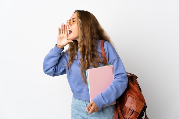 Young student woman isolated on white shouting with mouth wide open to the side